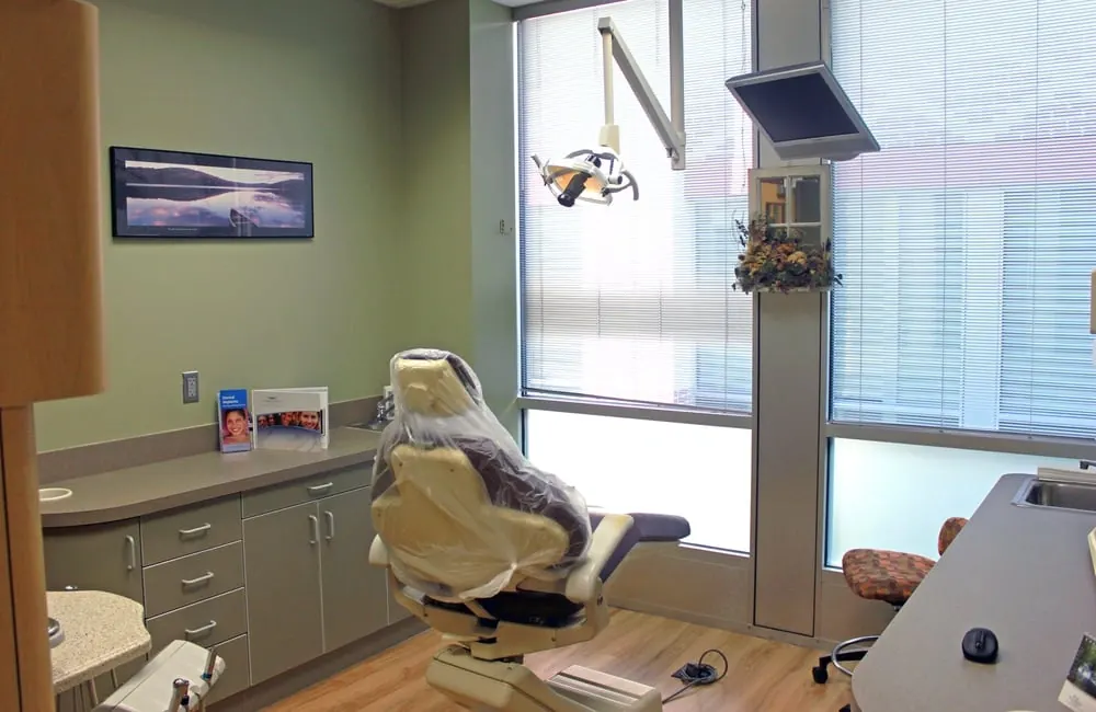 A treatment room at Twin Hickory Dental, with the dental chair by the window and a monitor overhead.
